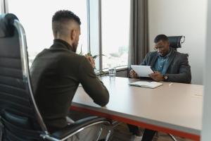 dois homens negros conversando em uma mesa de trabalho