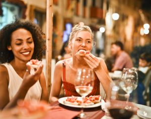 mulheres em um restaurante comendo e rindo